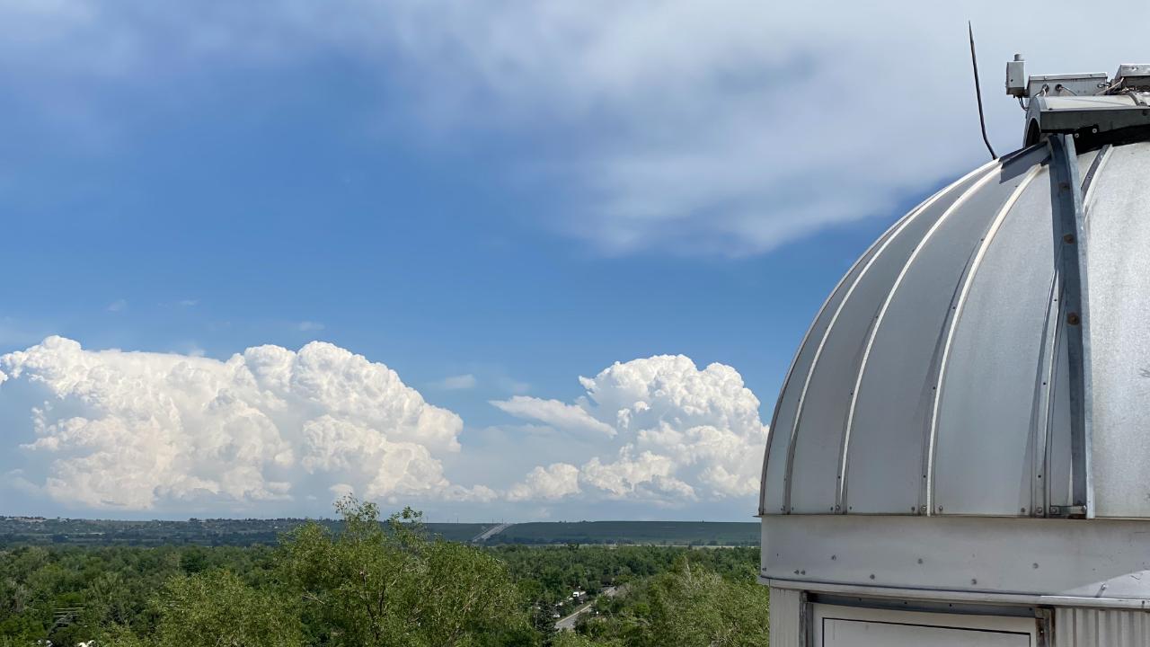 Instrument observation dome with thunderstorm clouds in the distance