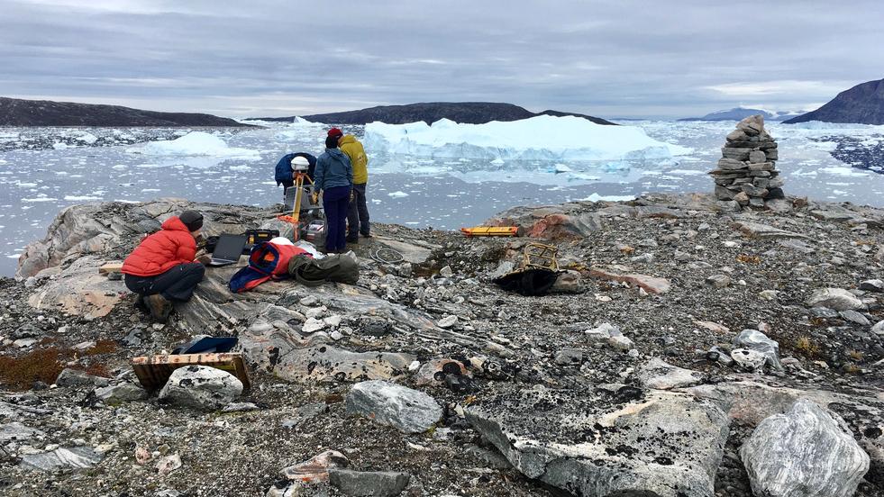 People setting up a field observation instrument in northwestern Greenland